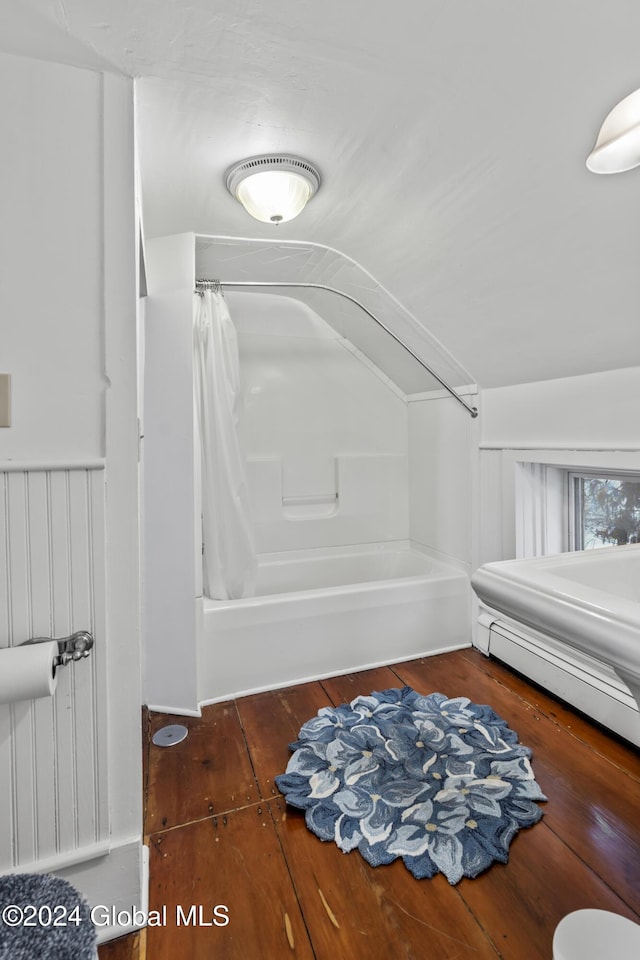 bathroom with vaulted ceiling, hardwood / wood-style floors, and shower / bath combo with shower curtain