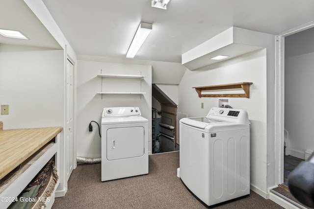 washroom featuring washer and dryer and dark carpet