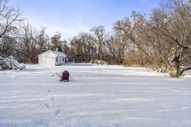 yard layered in snow with an outbuilding