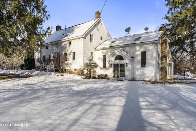 view of snow covered back of property