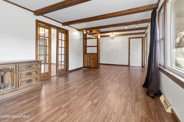 unfurnished living room with french doors, dark hardwood / wood-style floors, crown molding, and beam ceiling