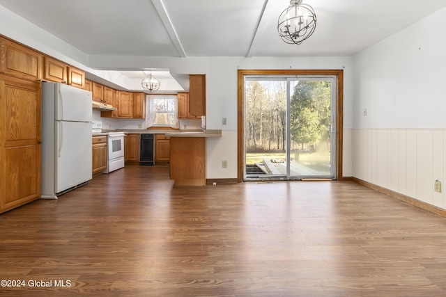 kitchen with pendant lighting, white appliances, a notable chandelier, and hardwood / wood-style floors