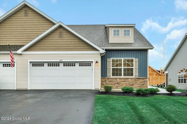 craftsman house with a garage and a front lawn