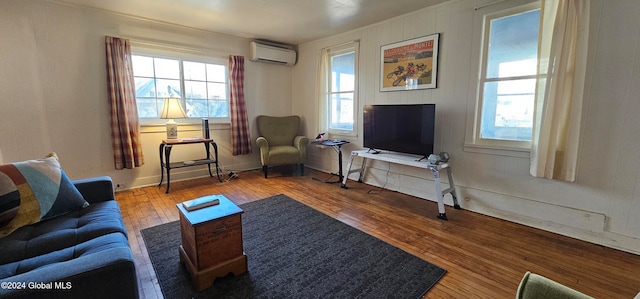 living room with hardwood / wood-style floors and an AC wall unit