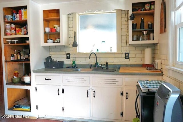 kitchen featuring decorative backsplash, a healthy amount of sunlight, white cabinetry, and sink