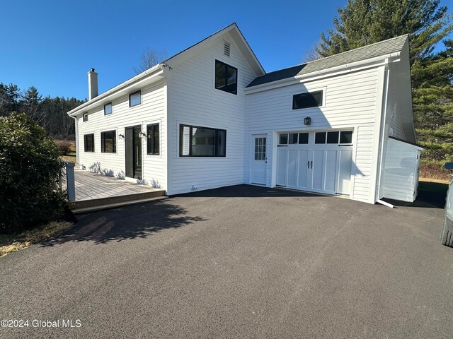 back of house featuring a garage and a deck