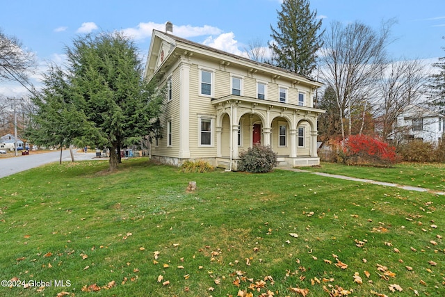 italianate-style house with a porch and a front lawn