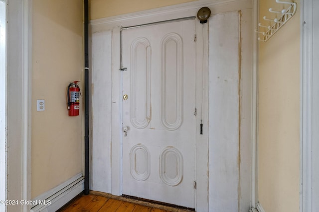 exterior details with wood-type flooring and a baseboard radiator