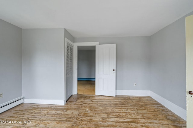 unfurnished room with light wood-type flooring and a baseboard radiator