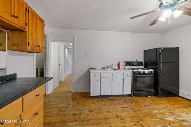 kitchen with sink, light hardwood / wood-style floors, ceiling fan, and black appliances