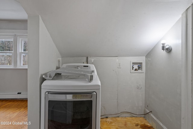 clothes washing area featuring hardwood / wood-style floors, a baseboard heating unit, and washer / dryer