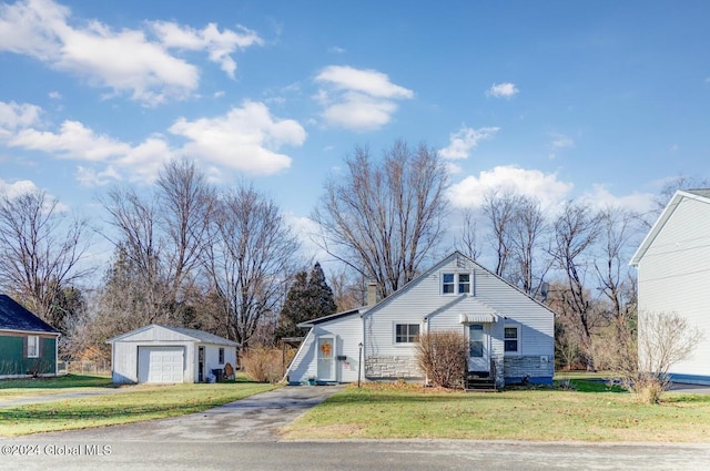 view of front of home with a front yard, a garage, and an outdoor structure