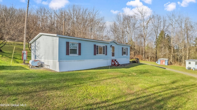 manufactured / mobile home with a shed and a front lawn