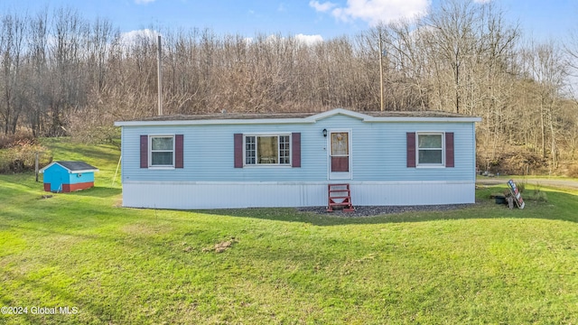 view of front of property featuring a storage unit and a front lawn