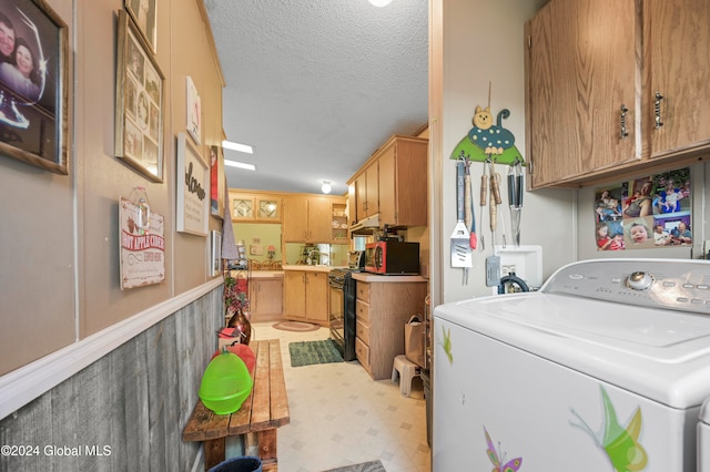 laundry room featuring cabinets, a textured ceiling, and washer / dryer