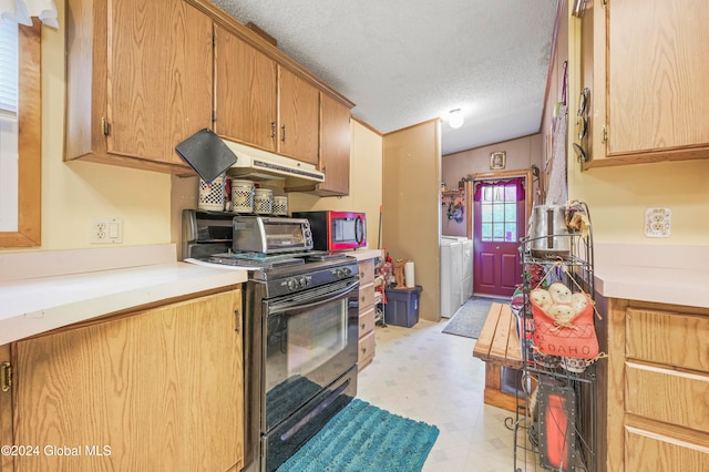 kitchen featuring washer and clothes dryer, black range, and a textured ceiling