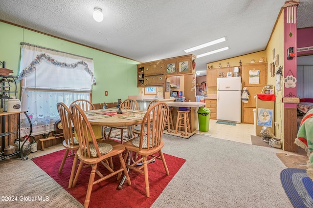 dining space with light colored carpet and a textured ceiling