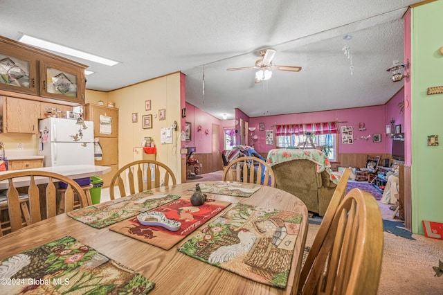 dining area with ceiling fan, wood-type flooring, and a textured ceiling