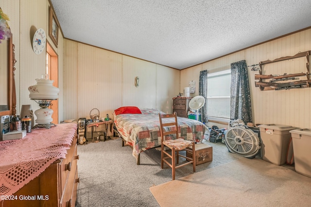 bedroom featuring wood walls, carpet floors, and a textured ceiling