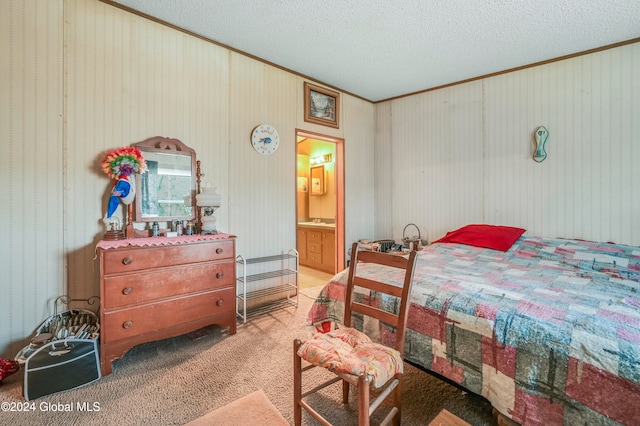 bedroom with crown molding, light colored carpet, a textured ceiling, and ensuite bath