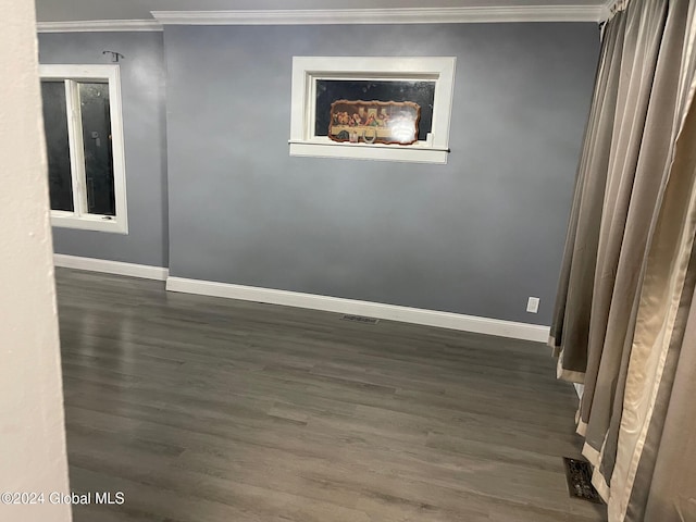 empty room featuring dark hardwood / wood-style floors and crown molding