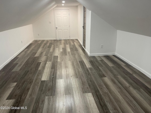 additional living space with vaulted ceiling and dark hardwood / wood-style floors