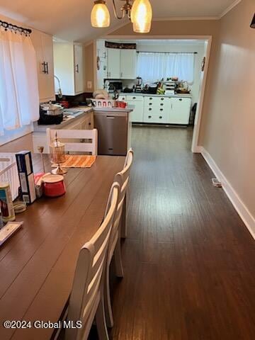 kitchen with a notable chandelier, white cabinets, dark hardwood / wood-style floors, ornamental molding, and decorative light fixtures