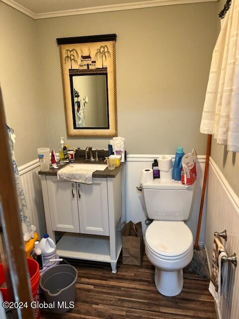 bathroom featuring hardwood / wood-style floors, vanity, toilet, and ornamental molding