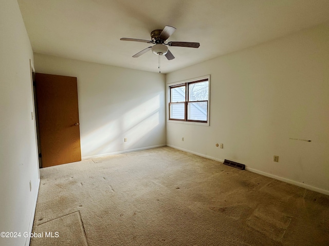 carpeted spare room with ceiling fan