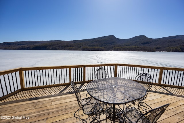 wooden terrace featuring a water and mountain view