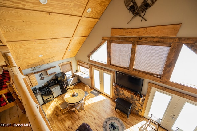 living room with french doors, high vaulted ceiling, and light wood-type flooring