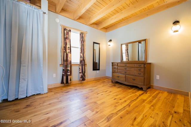 unfurnished bedroom featuring beam ceiling, light wood-type flooring, and wooden ceiling