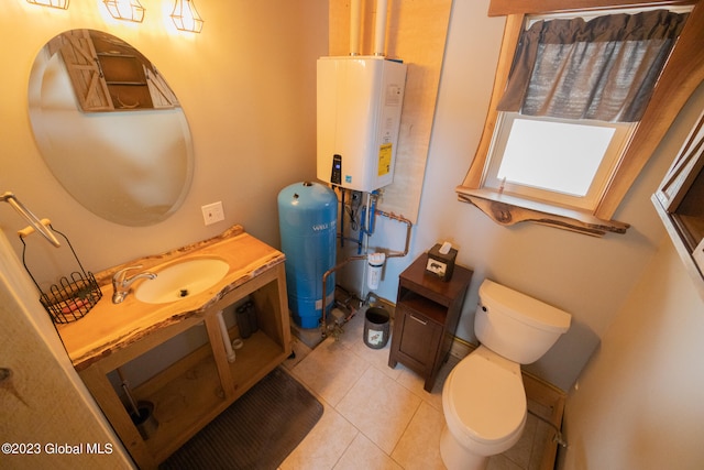 bathroom featuring tile patterned floors, vanity, tankless water heater, and toilet