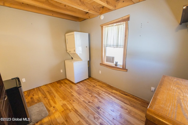 laundry area with stacked washer and dryer, wood ceiling, and light hardwood / wood-style flooring