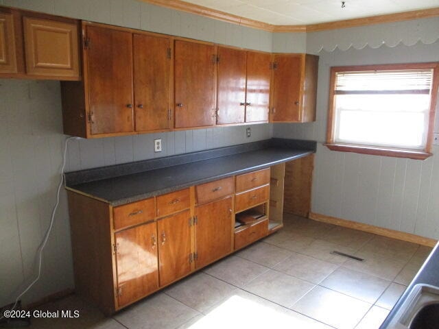 kitchen with ornamental molding and light tile patterned flooring