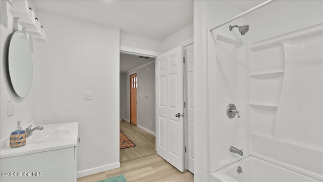 bathroom featuring hardwood / wood-style flooring, vanity, and shower / bath combination