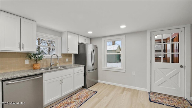 kitchen featuring plenty of natural light, white cabinetry, sink, and appliances with stainless steel finishes