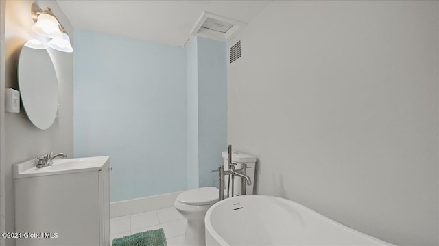 bathroom featuring toilet, vanity, tile patterned floors, and a washtub