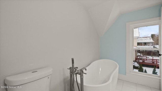 bathroom with tile patterned floors, toilet, and a bath