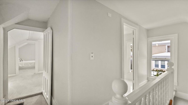 corridor with carpet floors and lofted ceiling