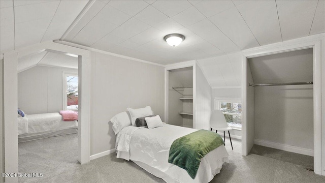 carpeted bedroom with vaulted ceiling and multiple windows