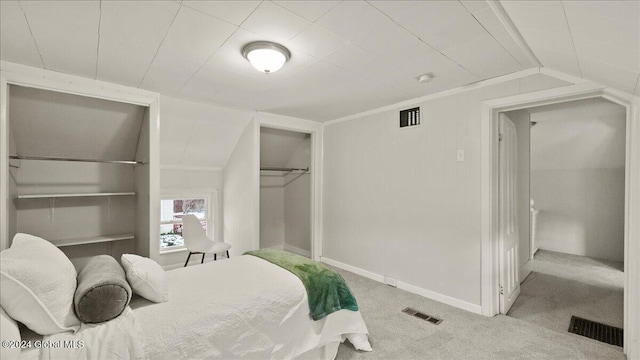 bedroom with a closet, light colored carpet, and vaulted ceiling