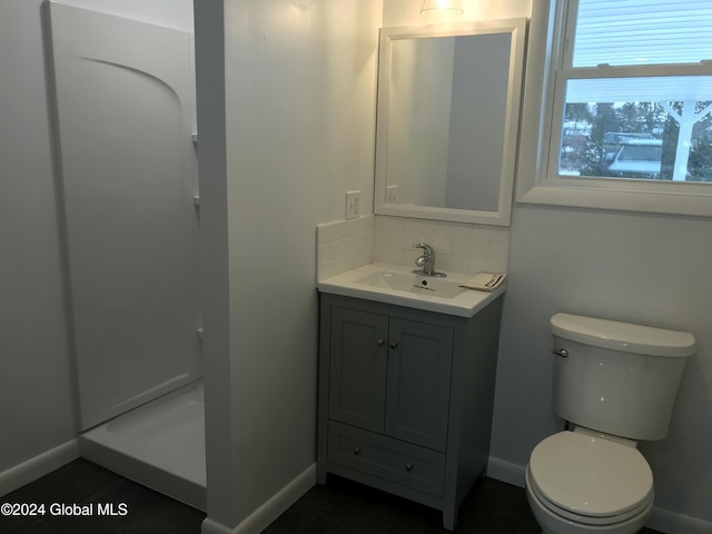 bathroom featuring walk in shower, vanity, and toilet