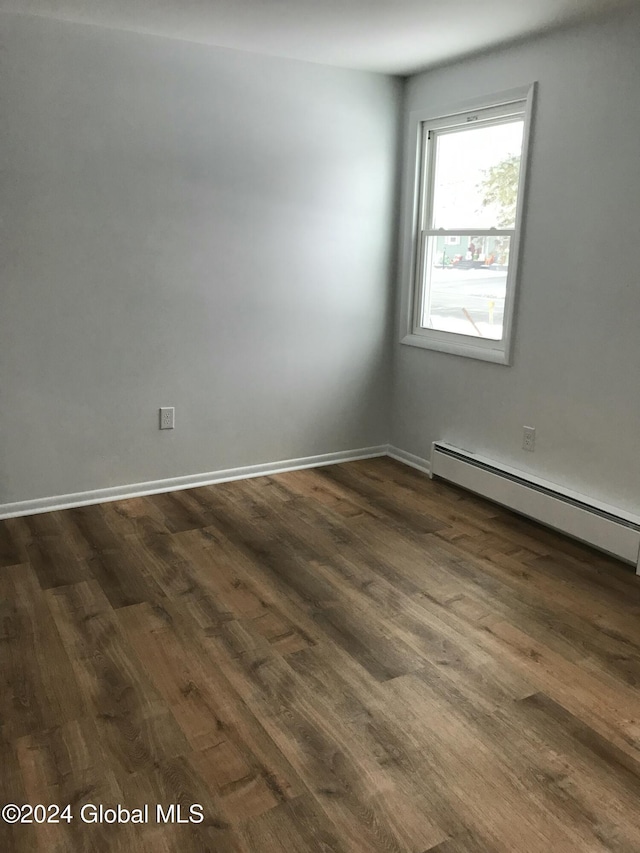 spare room featuring dark hardwood / wood-style floors and a baseboard radiator