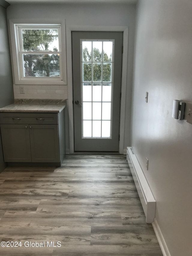 doorway featuring light hardwood / wood-style floors and a baseboard heating unit