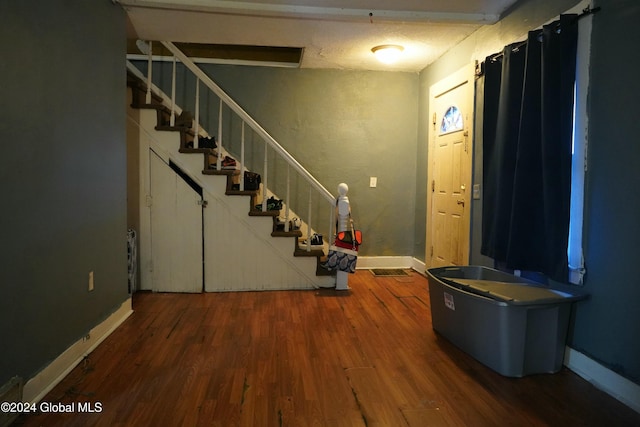 foyer featuring dark wood-type flooring and a textured ceiling