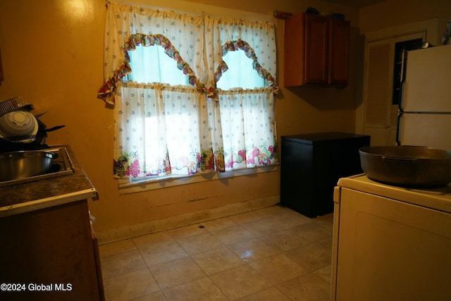 washroom with washer / clothes dryer, sink, and light tile patterned floors