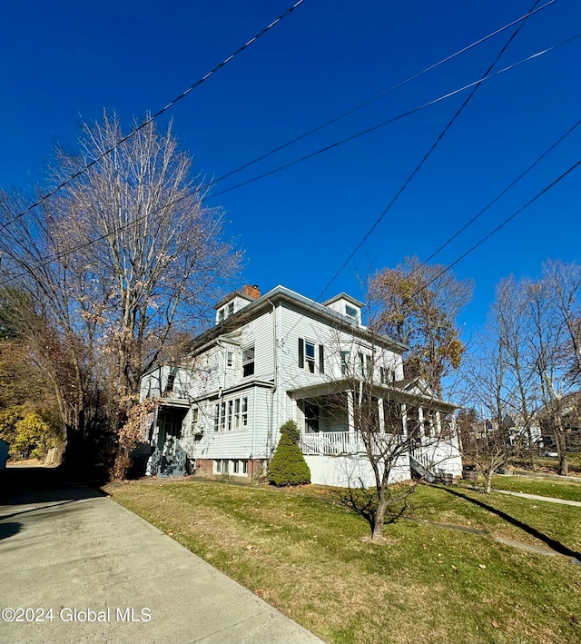 view of property exterior with a porch and a yard