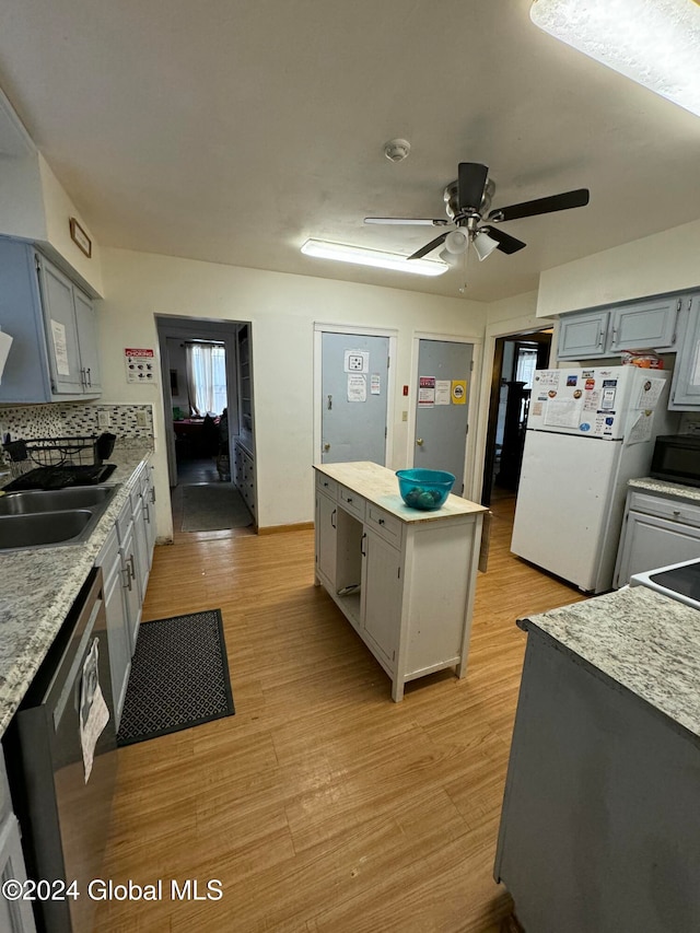 kitchen with stainless steel dishwasher, gray cabinetry, ceiling fan, white refrigerator, and light hardwood / wood-style floors