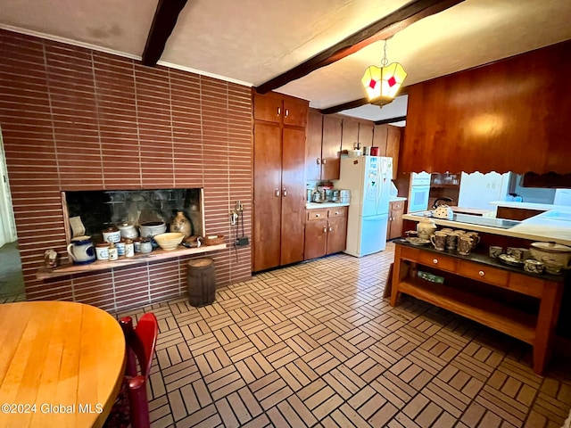 kitchen with hanging light fixtures, beamed ceiling, white fridge, wooden walls, and a fireplace